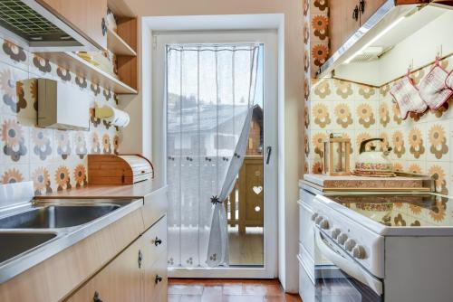 a kitchen with a sink and a stove at Ciasa Christina - Attic in Moena