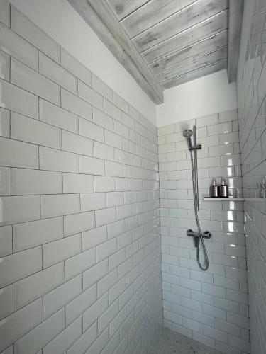 a white tiled shower with a shower head in a bathroom at Apartamento Romero in Arrecife