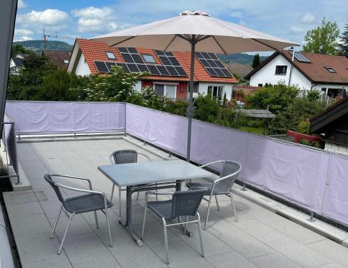 a table and chairs with an umbrella on a patio at Ferienwohnung Käppeler in Salem