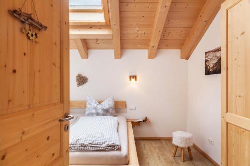 a small bedroom with a bed and a wooden door at Apartment Ferienhaus Huber in Grainau