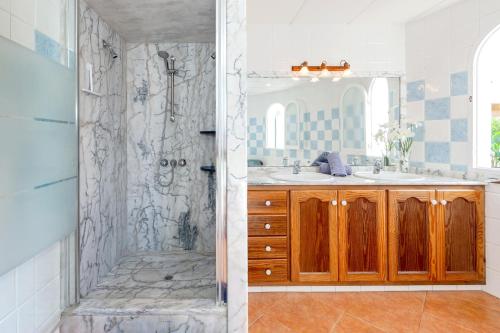 a bathroom with a shower and a sink at Chalet Es Llossar in Cala en Blanes