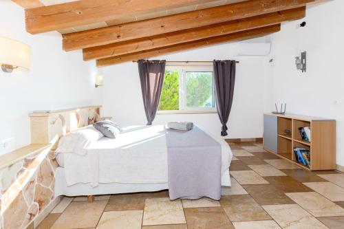 a bedroom with a bed and a window at Chalet Es Llossar in Cala en Blanes
