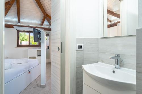 a white bathroom with a sink and a mirror at Villa Luana con piscina in Noto