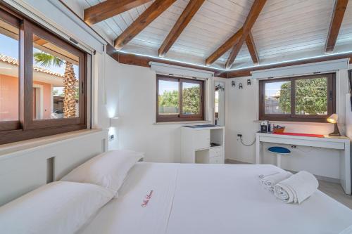 a bedroom with a white bed and windows at Villa Luana con piscina in Noto