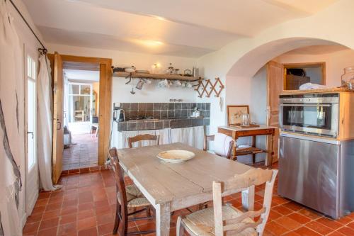 ein Esszimmer mit einem Tisch und einer Küche in der Unterkunft La Maison de Constance in Cavalaire-sur-Mer