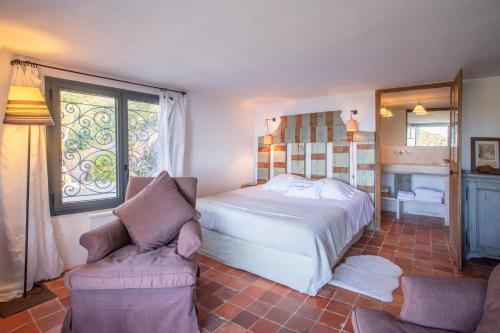 ein Schlafzimmer mit einem Bett und einem Stuhl in der Unterkunft La Maison de Constance in Cavalaire-sur-Mer
