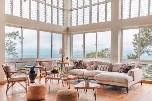 a living room with a couch and a lot of windows at Stunning villa w pool & mountain view in Jarabacoa in Jarabacoa