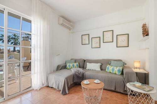 a living room with a couch and a table at Atico En Islantilla in Huelva