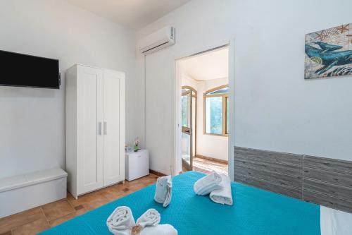 a room with a blue bed with towels on it at Villa Leale Plemmirio con piscina in Syracuse