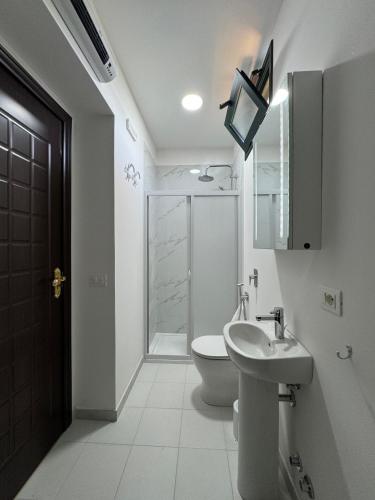 a white bathroom with a toilet and a sink at Villa Nino in Petacciato