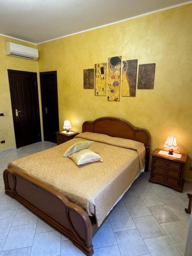 a bedroom with a bed with two night stands and two lamps at Villa Nino in Petacciato