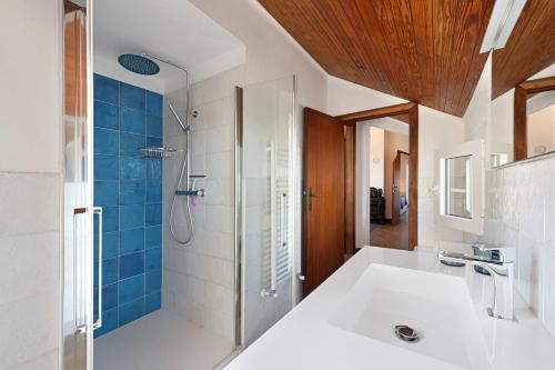 a bathroom with a shower and a white sink at Attico Con Vista in Moneglia