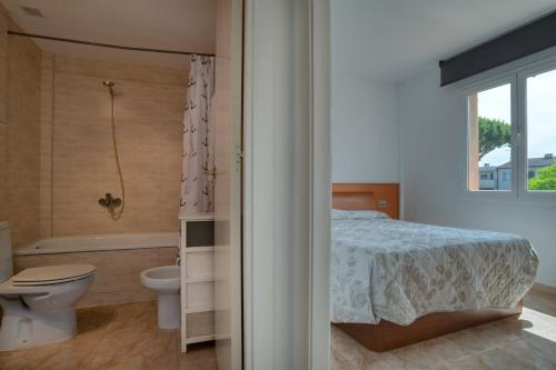 a bedroom with a bed and a tub and a toilet at Apartament a Sant Antoni de Calonge in Calonge