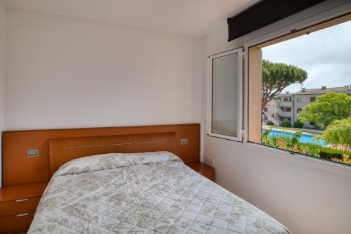 a bedroom with a bed and a large window at Apartament a Sant Antoni de Calonge in Calonge