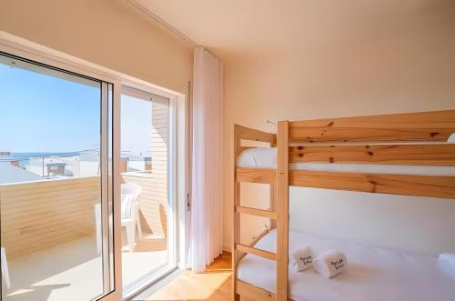 a bedroom with bunk beds and a balcony at T3 Moledo Com Piscina e Vista Mar in Moledo