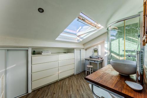 a bathroom with a sink and a skylight at La Chambre Dorée du Bassin in La Teste-de-Buch