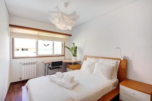 a bedroom with a bed with two towels on it at Cantinho da Praia da Barra in Gafanha da Nazaré