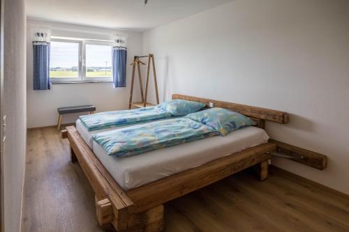 a bedroom with a wooden bed in a room with a window at Ferienwohnung Häfele 2 in Bad Wurzach