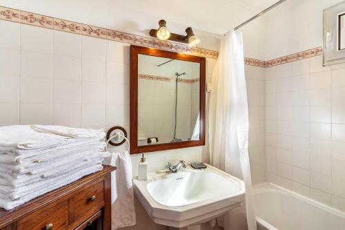 a white bathroom with a sink and a mirror at Villa Retiro in Canhas