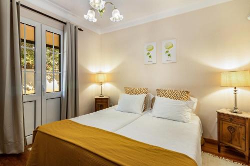 a bedroom with a bed with two lamps and a window at Villa Retiro in Canhas