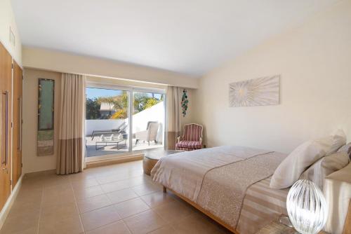 a bedroom with a bed and a view of a patio at Villa Nicola in Vale do Lobo