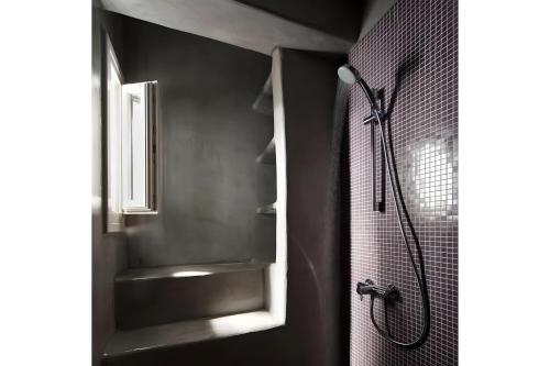 a bathroom with a shower and a sink and a window at Echinousa Kimolos katoikia no2 in Kimolos