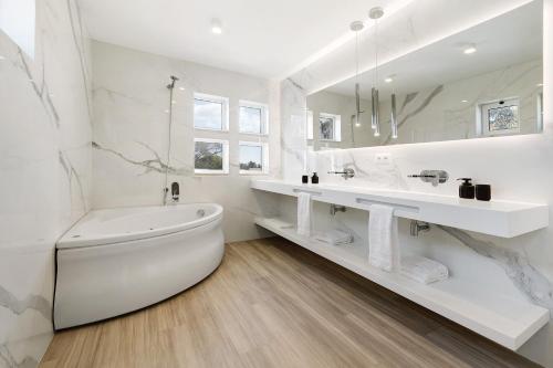 a white bathroom with a tub and a sink at Soltroia Beach Court -Heated Pool in Troia