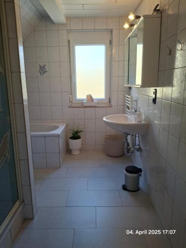 a bathroom with a sink and a toilet and a window at Im Grünen 2 in Weil der Stadt