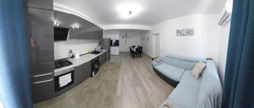a living room with a blue couch and a kitchen at Apart Alex in Constanţa