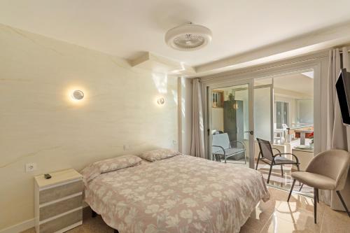 a bedroom with a bed and a balcony with chairs at Kellys' Apartment Las Camelias in San Bartolomé