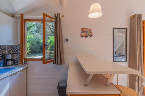 a small kitchen with a table and a window at La maisonnette en bois in Saumos