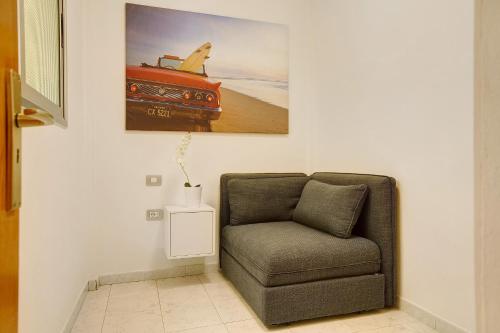 a living room with a chair and a picture of a car at Little Gem in Cruce de Arinaga