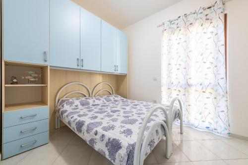 a small bedroom with a bed and a window at Casa Celeste in Villasimius