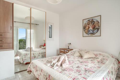 a white bedroom with a bed and a mirror at Casa Miranda in Kefallonia
