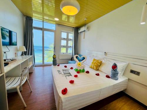 a bedroom with a bed with flowers on it at VIVA Beach Maldives in Hangnaameedhoo