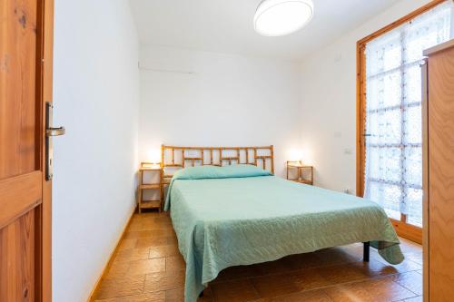 a bedroom with a bed with a green bedspread at Villa Costa Paradiso del Sud in Costa Rei