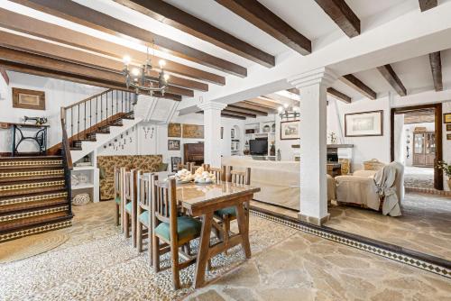 a dining room with a table and a living room at Cortijo Caracate in Archidona