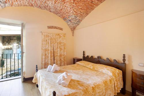 a bedroom with a bed and a large window at Le scale, borgo dei pescatori in Cervo