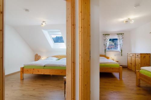 a bedroom with two beds and two windows at Albpartments in Meßstetten