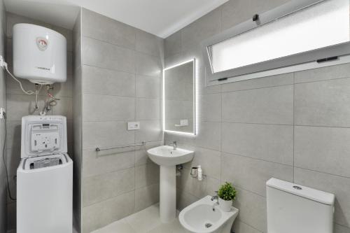 a white bathroom with a sink and a toilet at Apartamento Iris Tropical in Araya