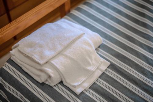 a white towel sitting on top of a bed at La Capannuccia C in Ansedónia