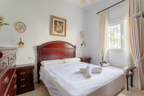 a bedroom with a bed and a dresser and a window at Villa Gallardo in Campillos