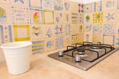 a stove top in a kitchen with a wall of tiles at Casa Sveva a Otranto vista mare in Otranto