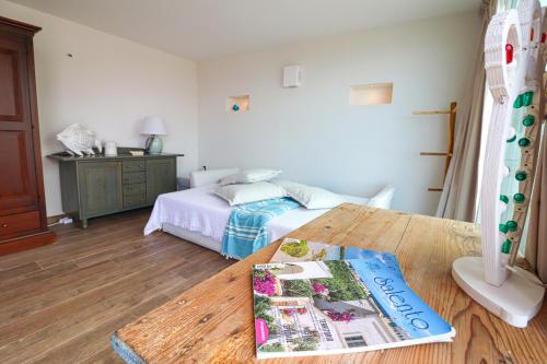 a bedroom with a bed and a book on a table at Casa Sveva a Otranto vista mare in Otranto