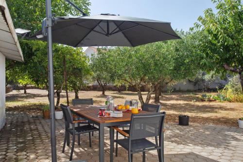 a table and chairs with an umbrella on a patio at Refúgio de Fátima in Fátima
