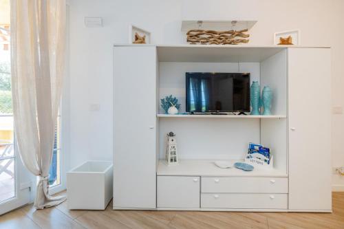 a white cabinet with a tv in a room at Isabel Beach and Bike in Finale Ligure