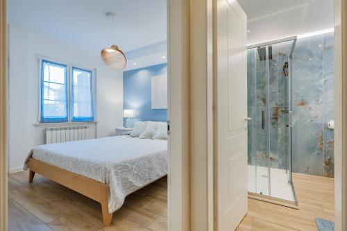 a bedroom with a bed and a glass shower at Isabel Beach and Bike in Finale Ligure