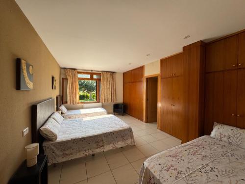 a hotel room with two beds and a window at Les Cabretes Vilanova de la Muga in Vilanova de la Muga