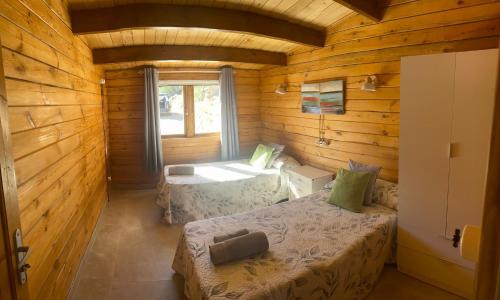 a room with two beds in a log cabin at Miralvalle in El Gastor