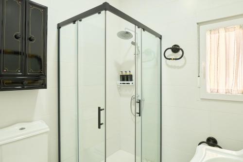 a shower with glass doors in a bathroom at Marisol' House in Puente Genil
